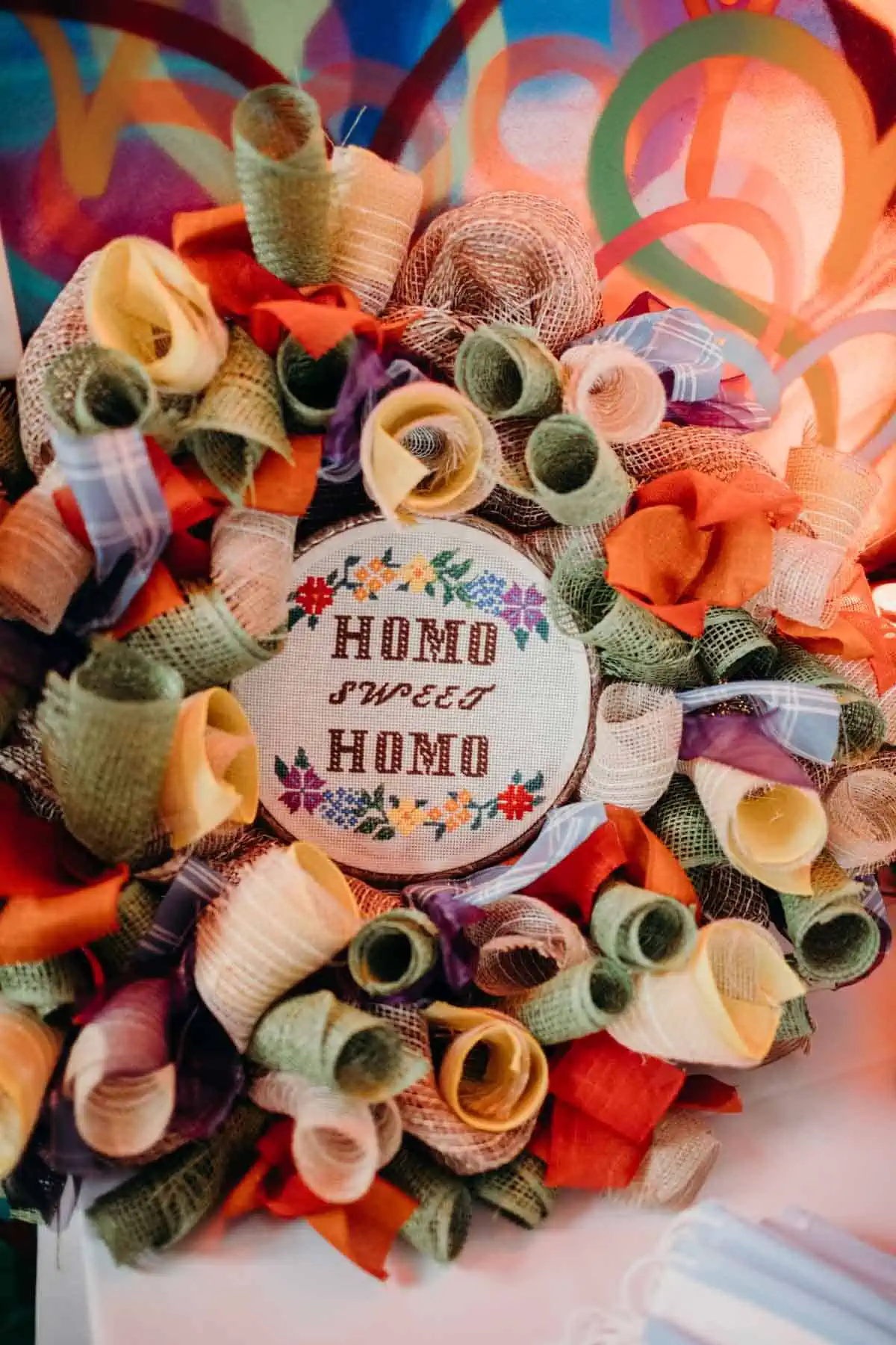 Homo Sweet Homo” embroidered decor at a colorful LGBTQ+ wedding.