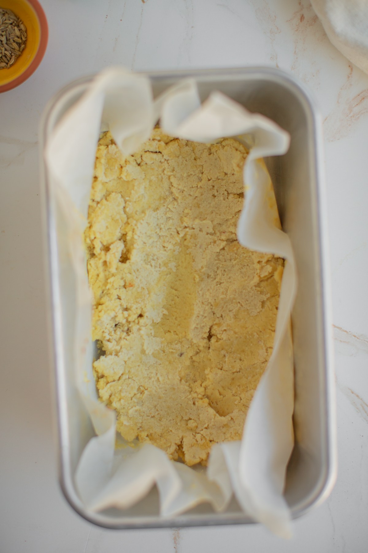 Baked vegan almond cheese in a loaf pan.