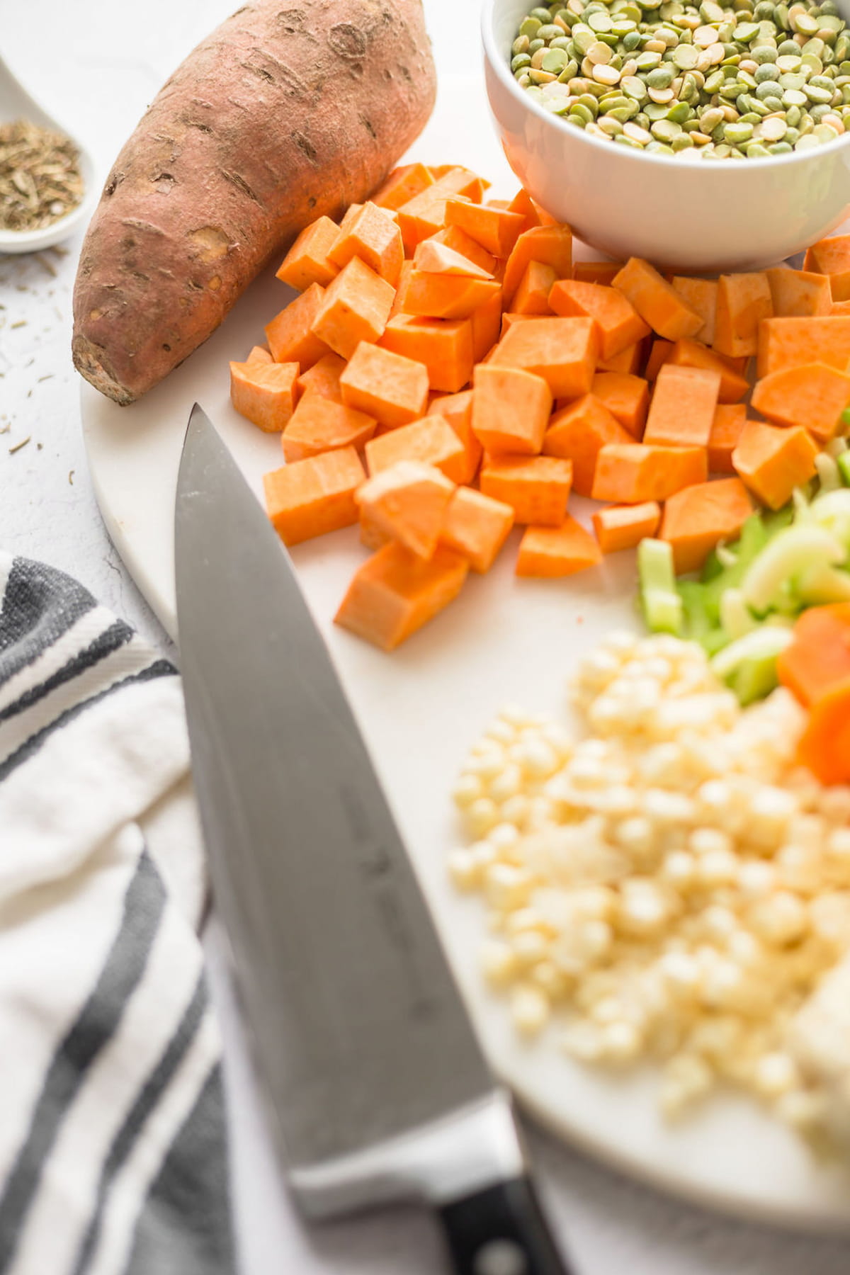Prepared vegetables for this soup including chopped sweet potato, celery, carrots, and garlic.