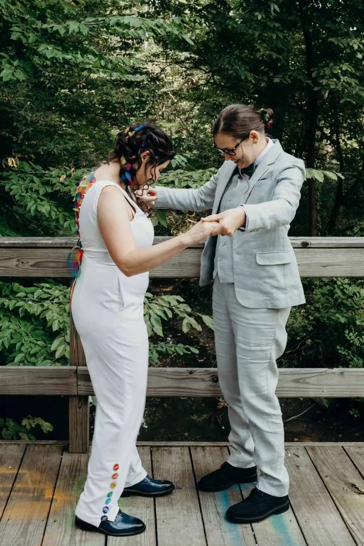 Vegan wedding brides admiring each other's wedding suits and colorful outfits.