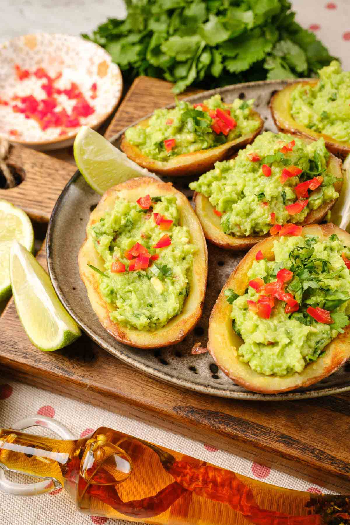A plate of loaded potato skins, filled with guacamole.