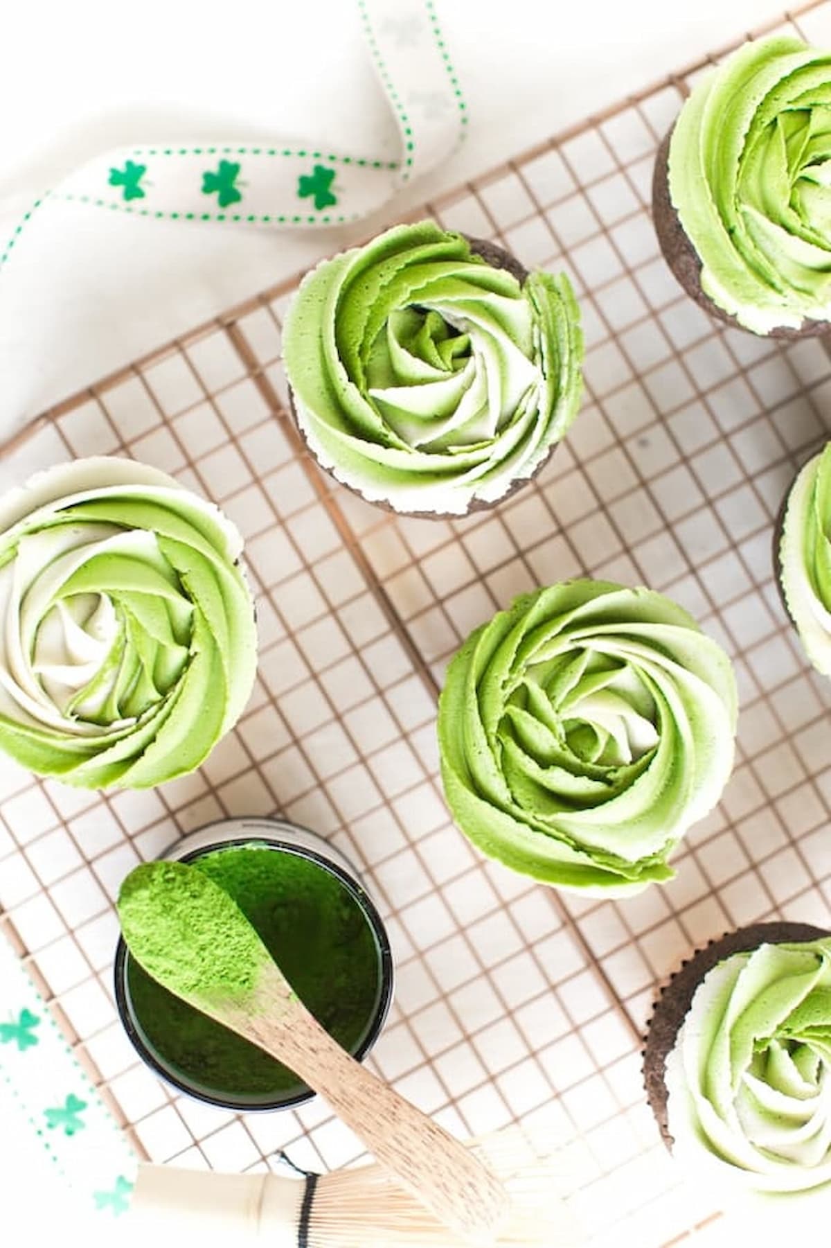 Matcha buttercream chocolate cupcakes on a cooling rack.