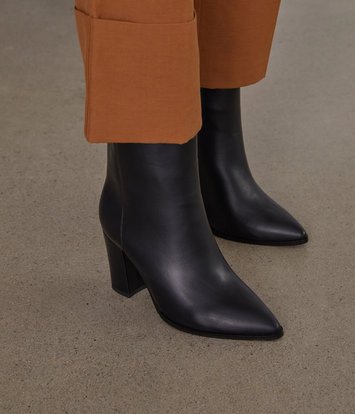 Pointy back elegant vegan leather boots from Matt and Nat, modeled with orange trouser pants.