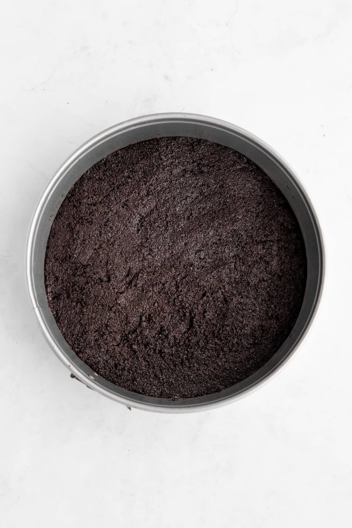 Oreo pie crust pressed into a springform pan.