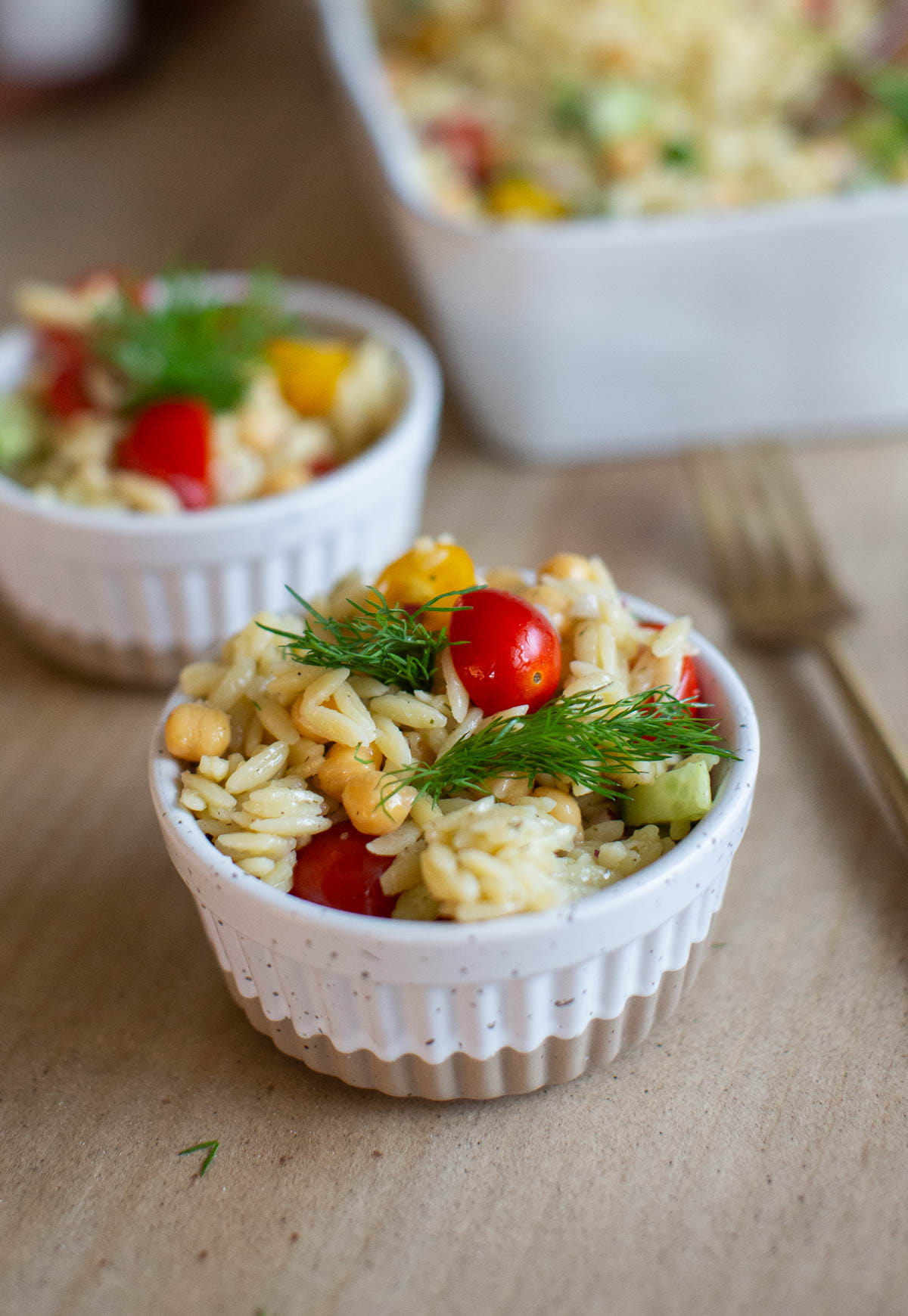 Small ramekins filled with chickpea orzo salad.