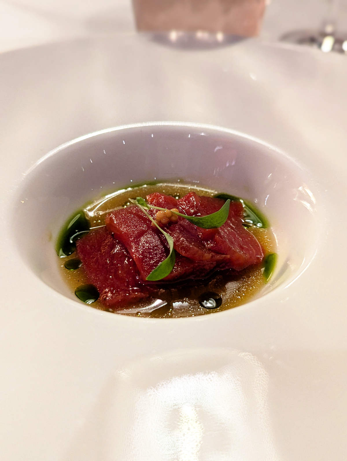 Vegan watermelon tuna with cucumber ponzu and pickled black radish in a bowl.