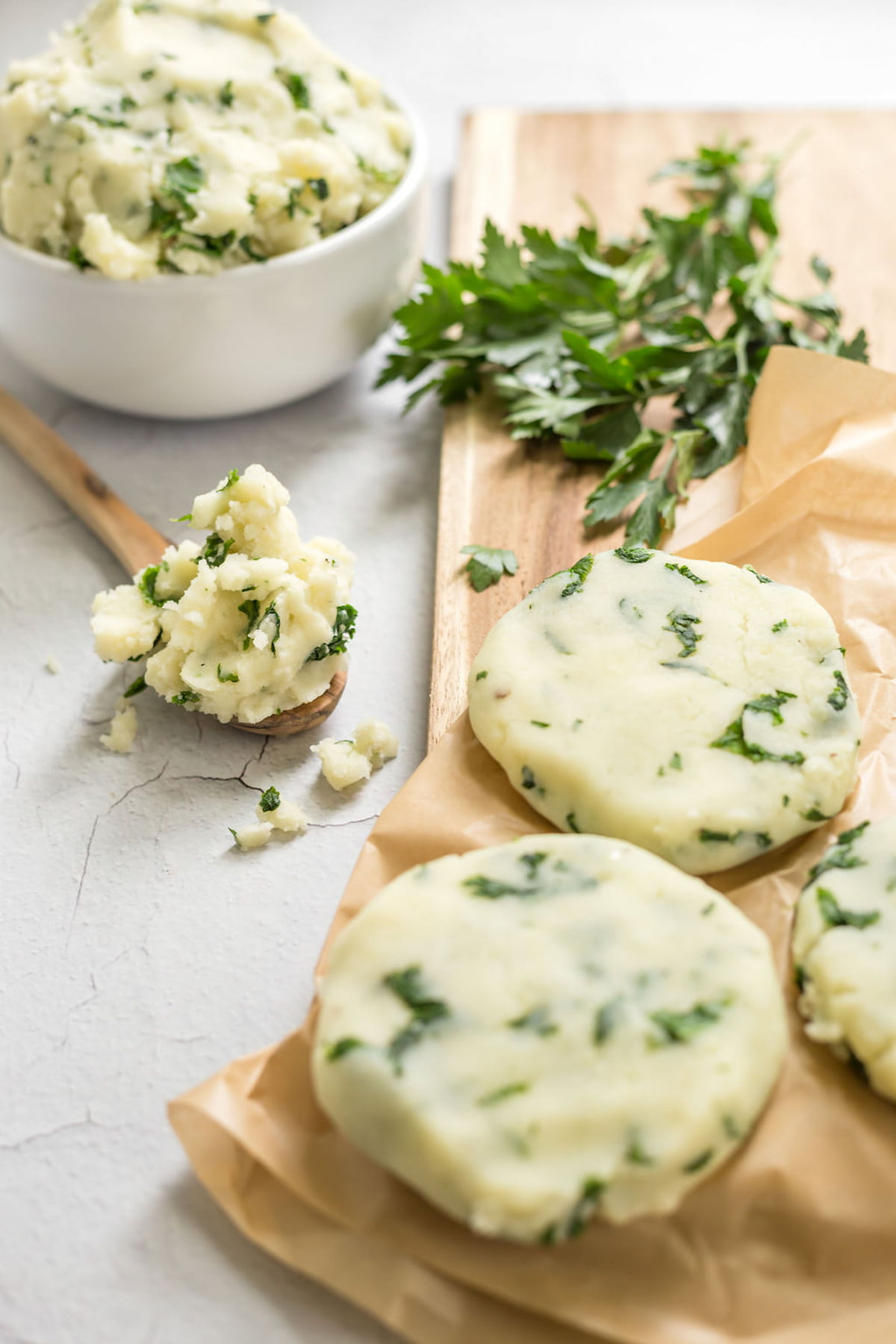 Potato cake patties shaped and placed on parchment paper.