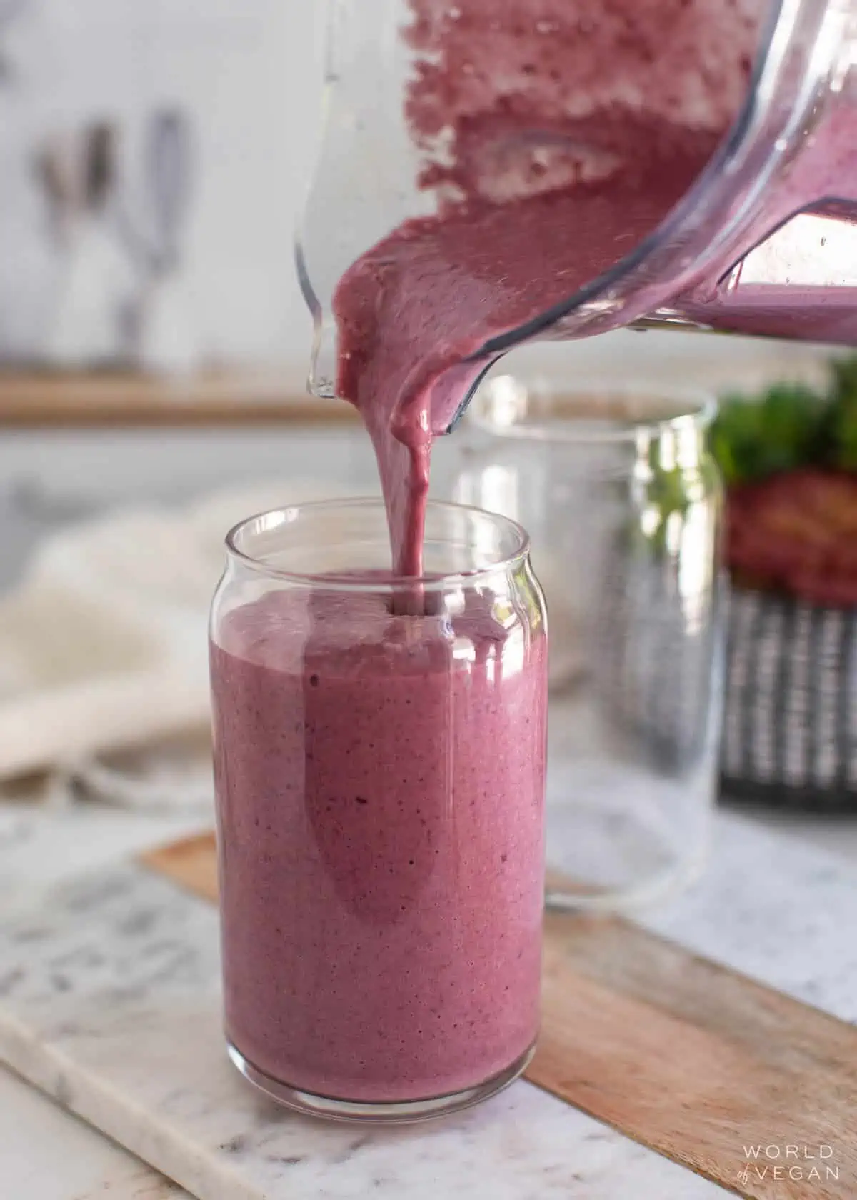 A high-protein vegan smoothie being poured into a glass.