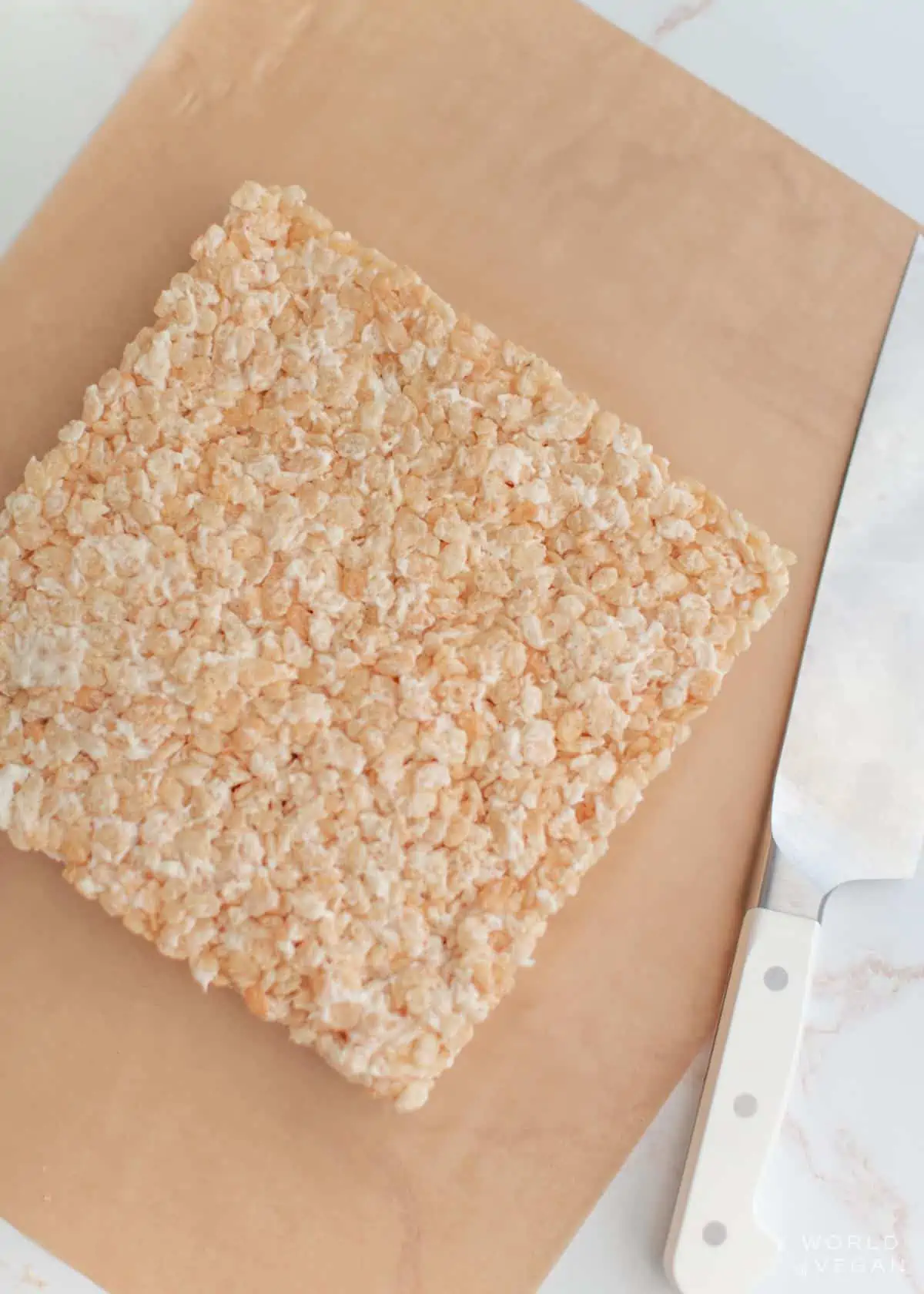 The finished frozen block of vegan rice crispies on a piece of parchment paper.