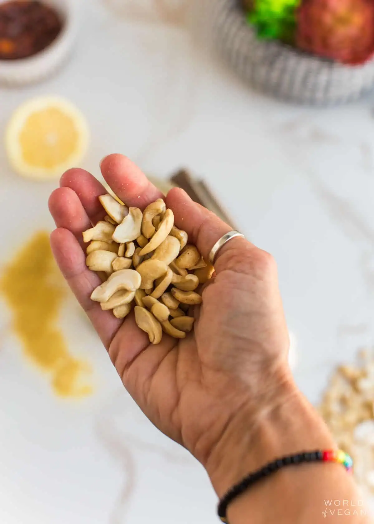 Raw cashews, one of the most common vegan pantry essentials, in the palm of a hand.
