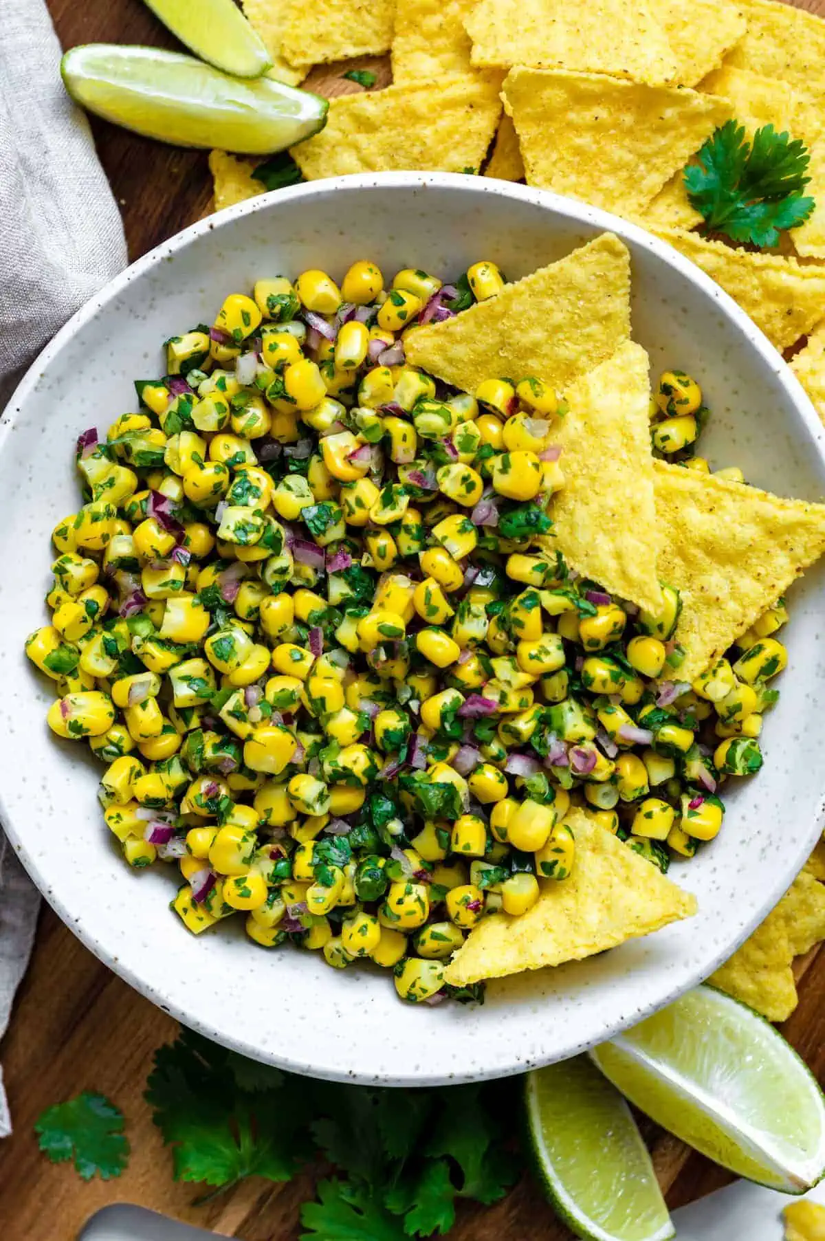 Roasted chili corn salsa in a bowl with tortilla chips, ideal for snacking at your summer cookout.