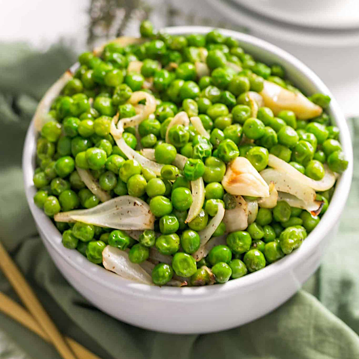 Roasted peas with onion and garlic in a large serving bowl.