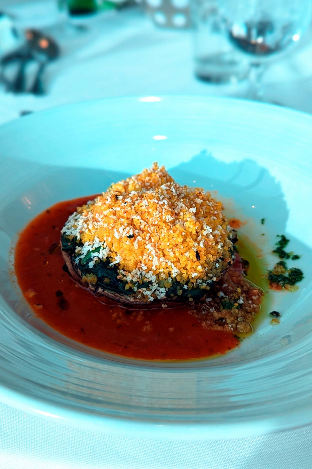 A portobello mushroom stuffed with creamed spinach and fluffy vegetable couscous baked in marinara.