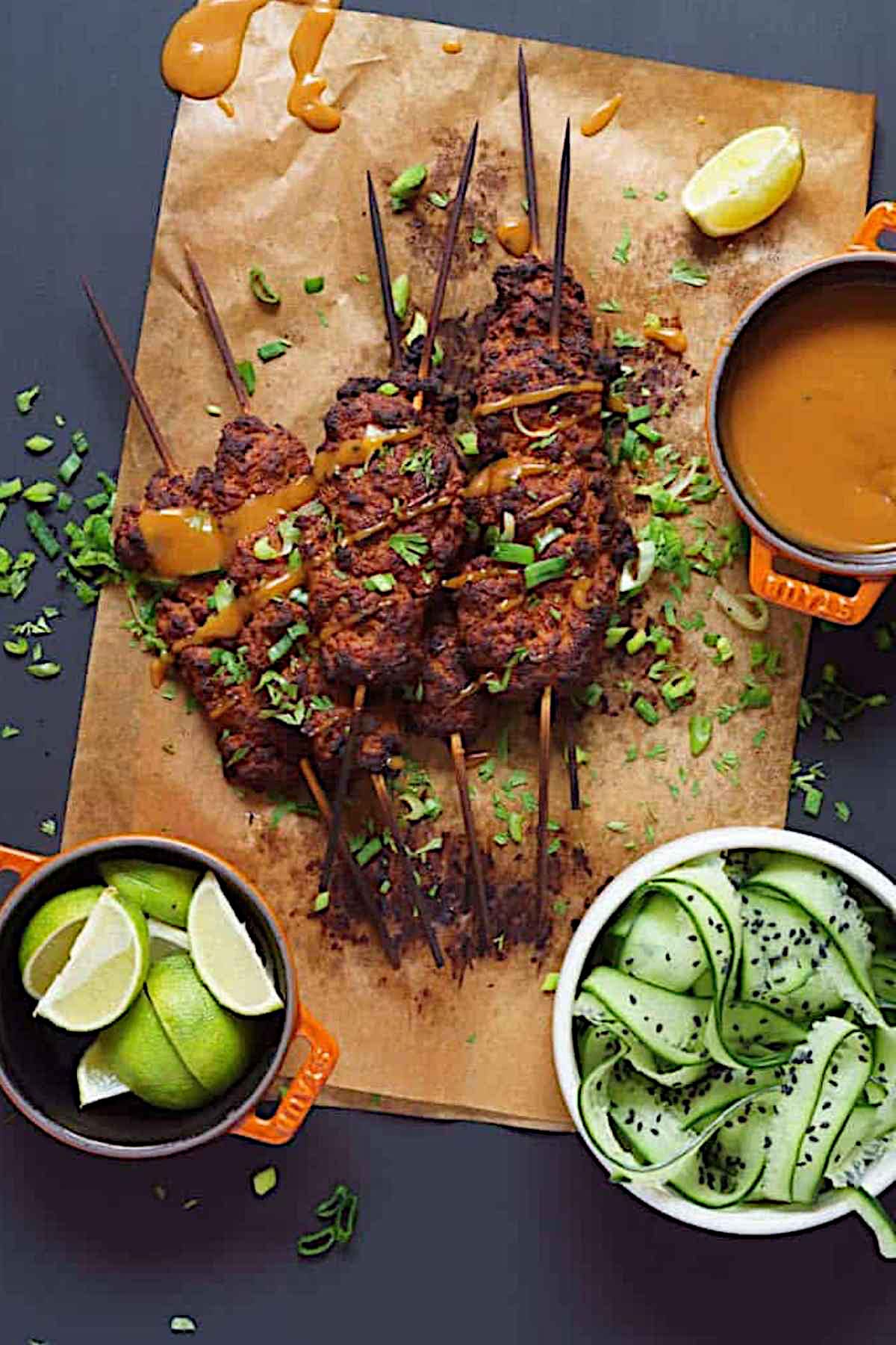 Seitan kebabs with peanut sauce and lime wedges.