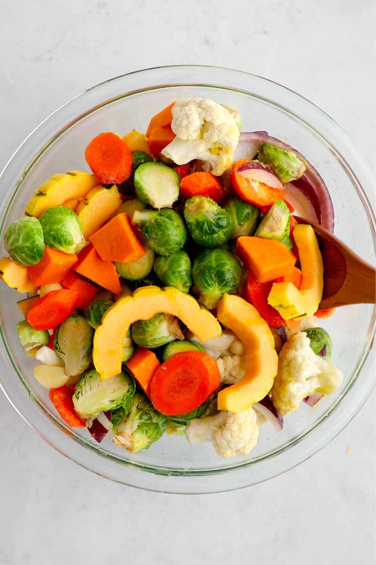 Chopped autumn veggies in a bowl tossed with seasonings.