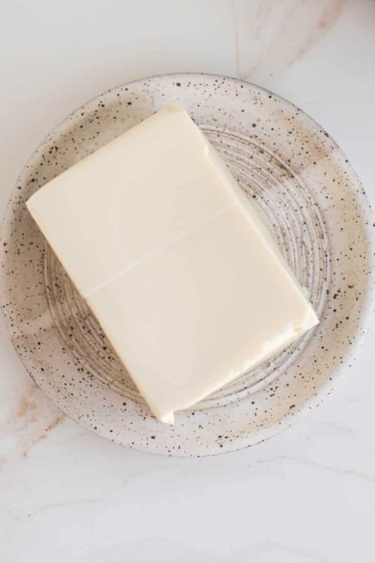 Silken tofu block sitting on a plate.