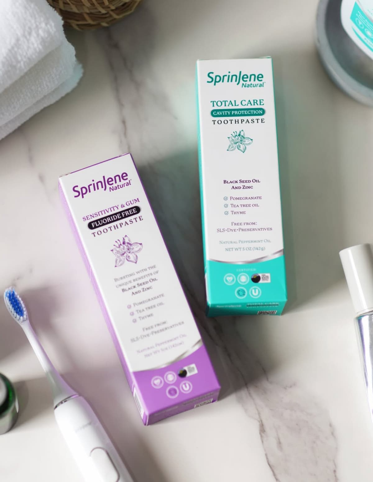 Two packages of SprinJene vegan toothpaste on a bathroom countertop.