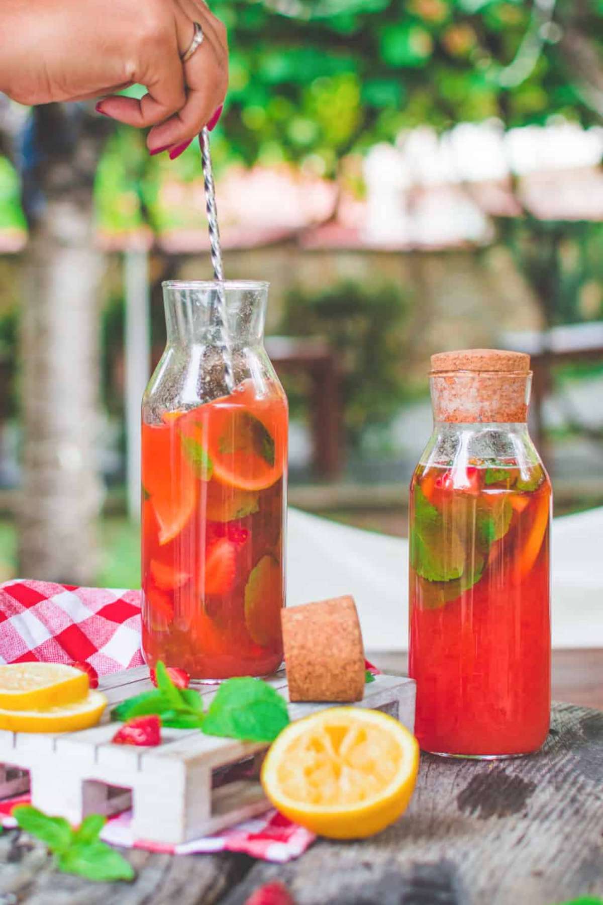 Bottles of homemade strawberry mint lemonade with fresh mint and lemon slices—perfect for summer BBQs.
