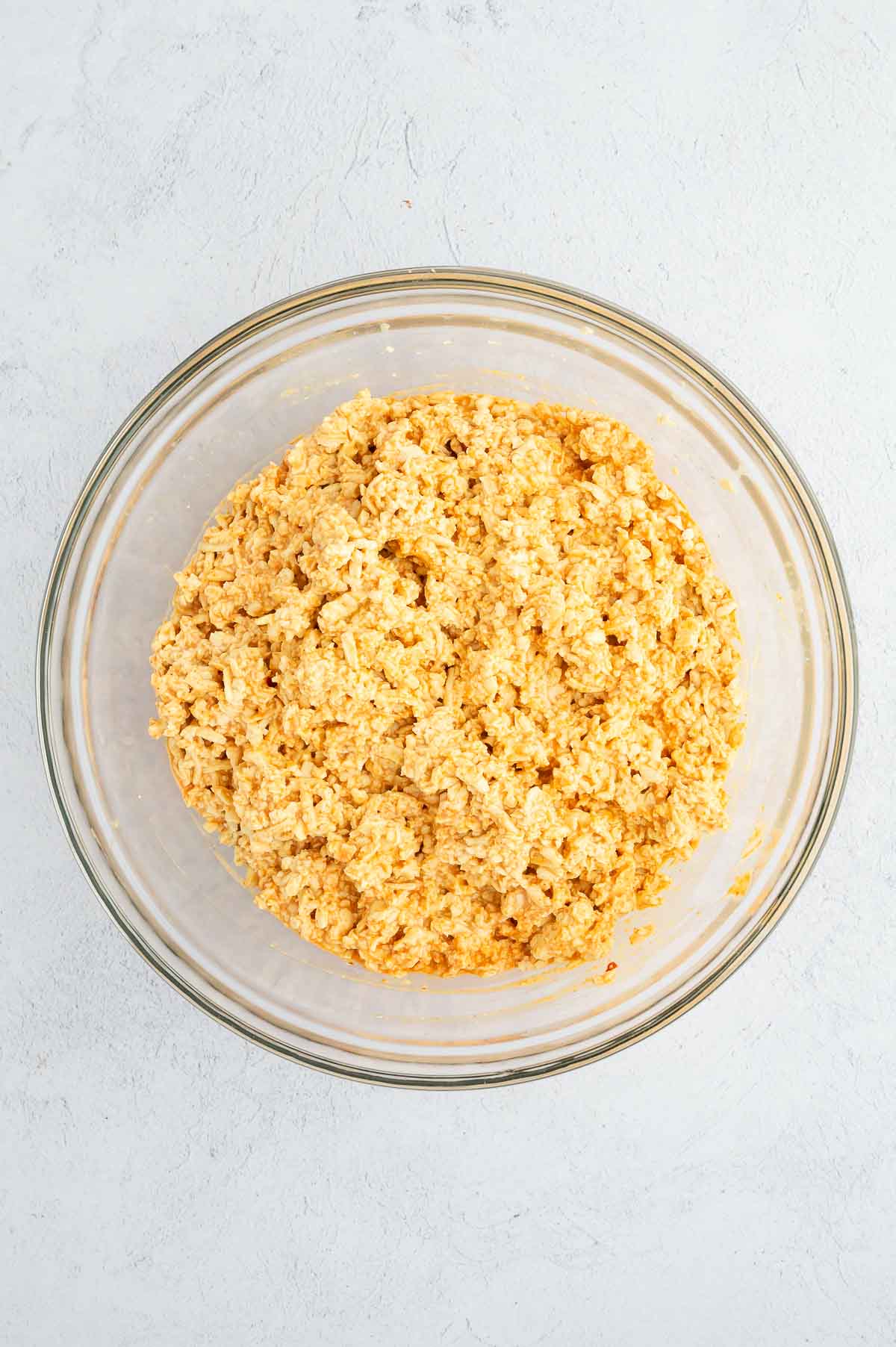 Seasoned shredded tofu in a mixing bowl after combining with spicy vegan mayo, forming the burrito filling.