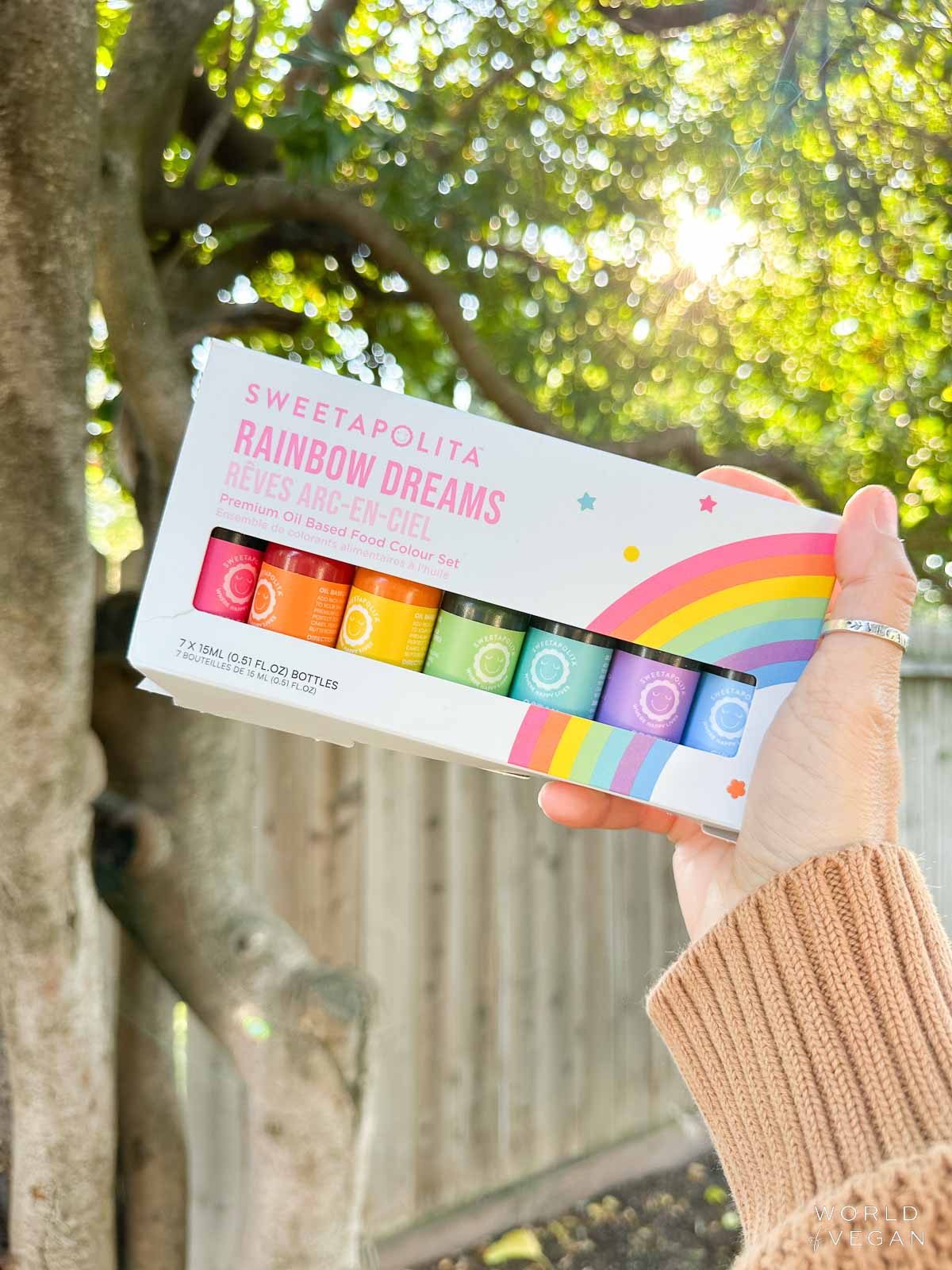 Holding out a box of vegan gel food coloring bottles from Sweetapolita.