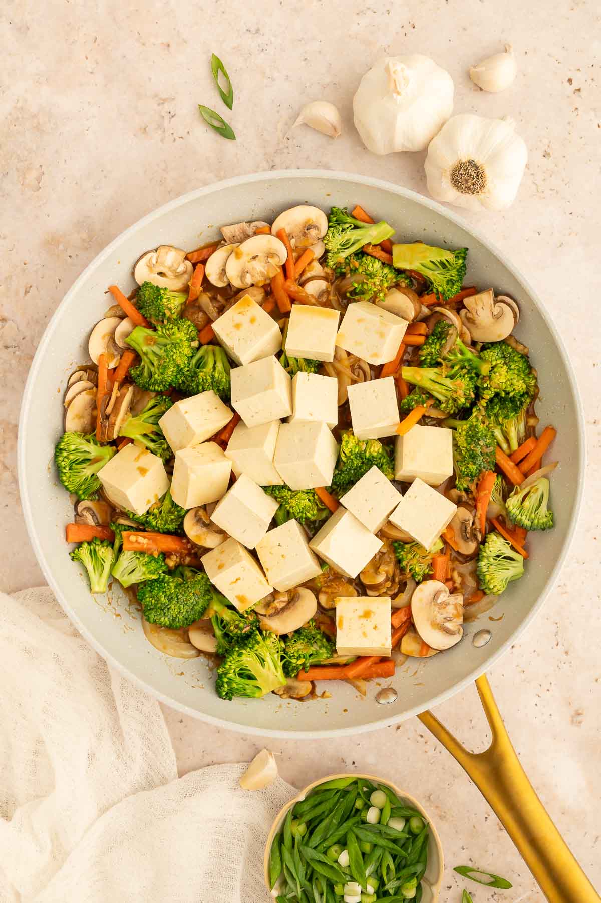 Tofu cubes added to a pan of vegetables for a quick tofu stir fry.