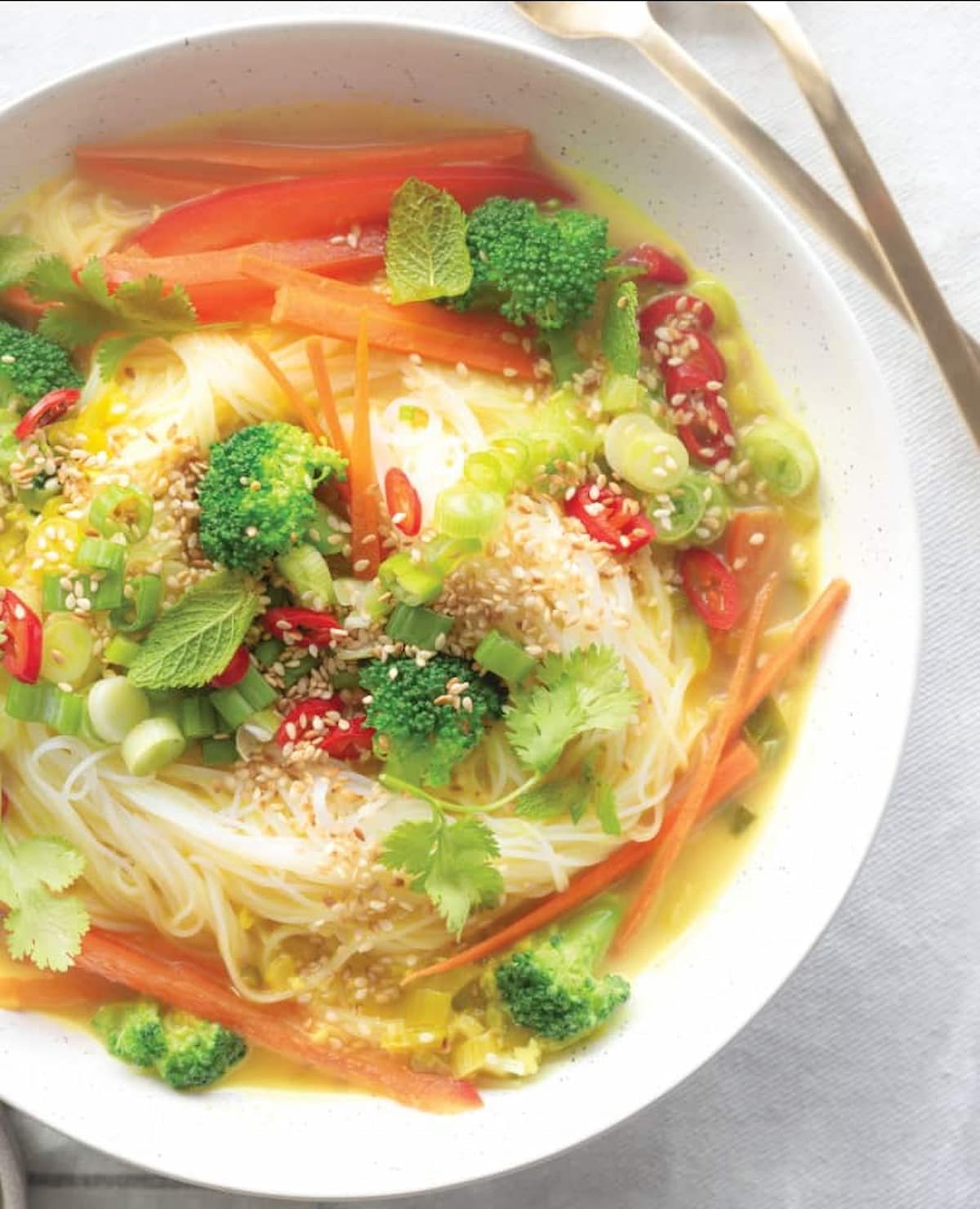 Thai vermicelli noodle soup with colorful vegetables and coconut curry broth.