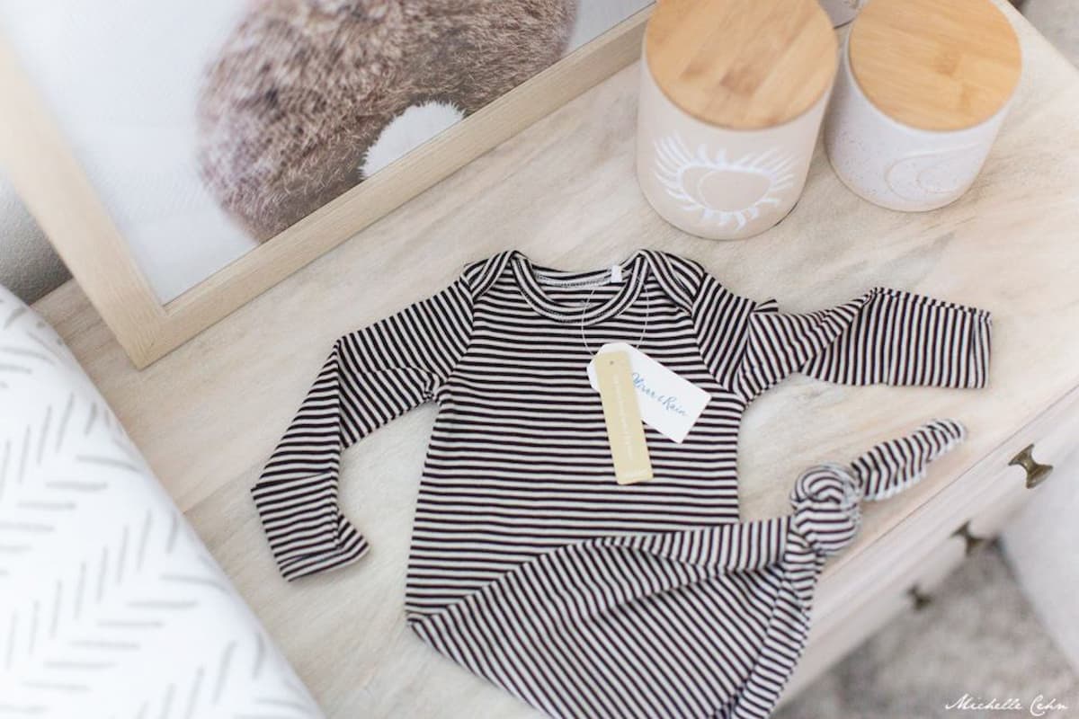 Vegan baby clothing on a dresser.