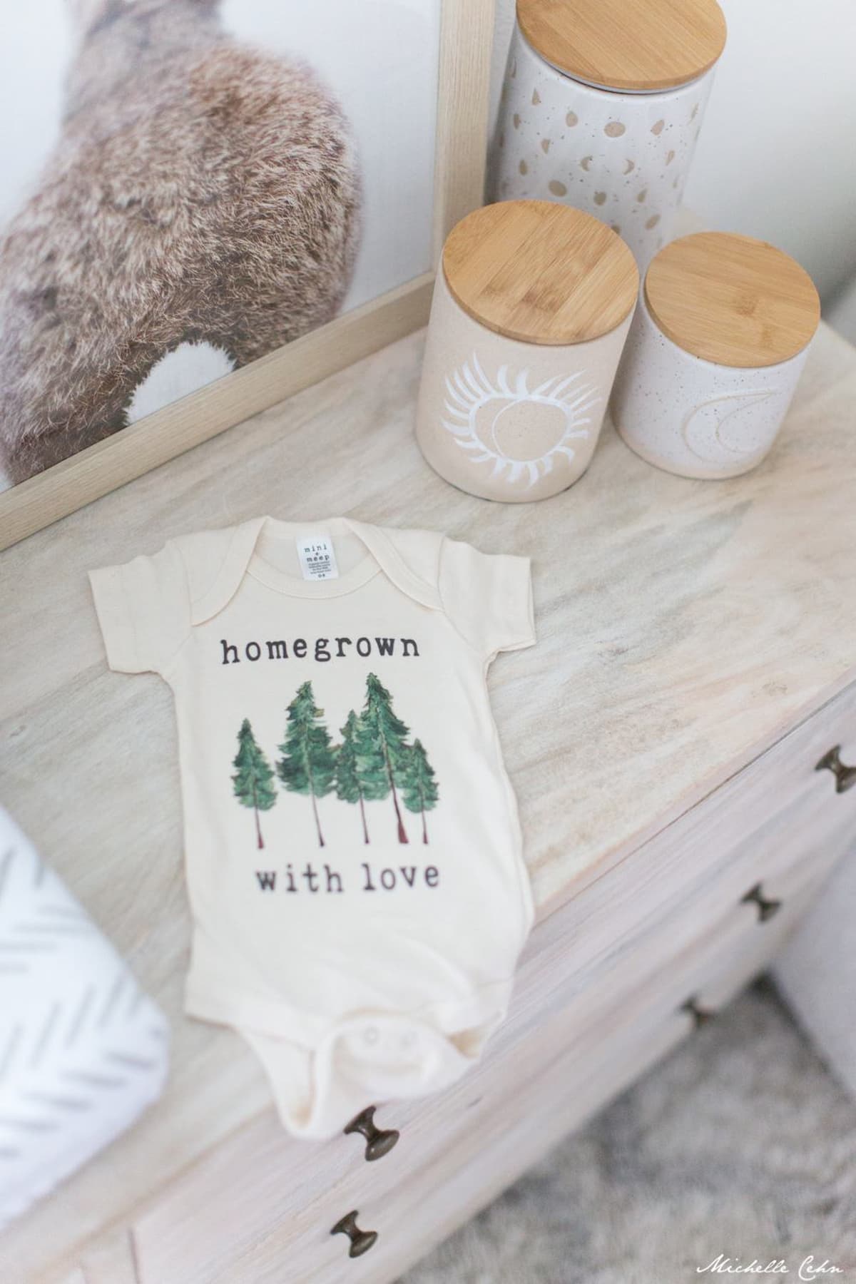 A vegan baby onesie on a dresser.