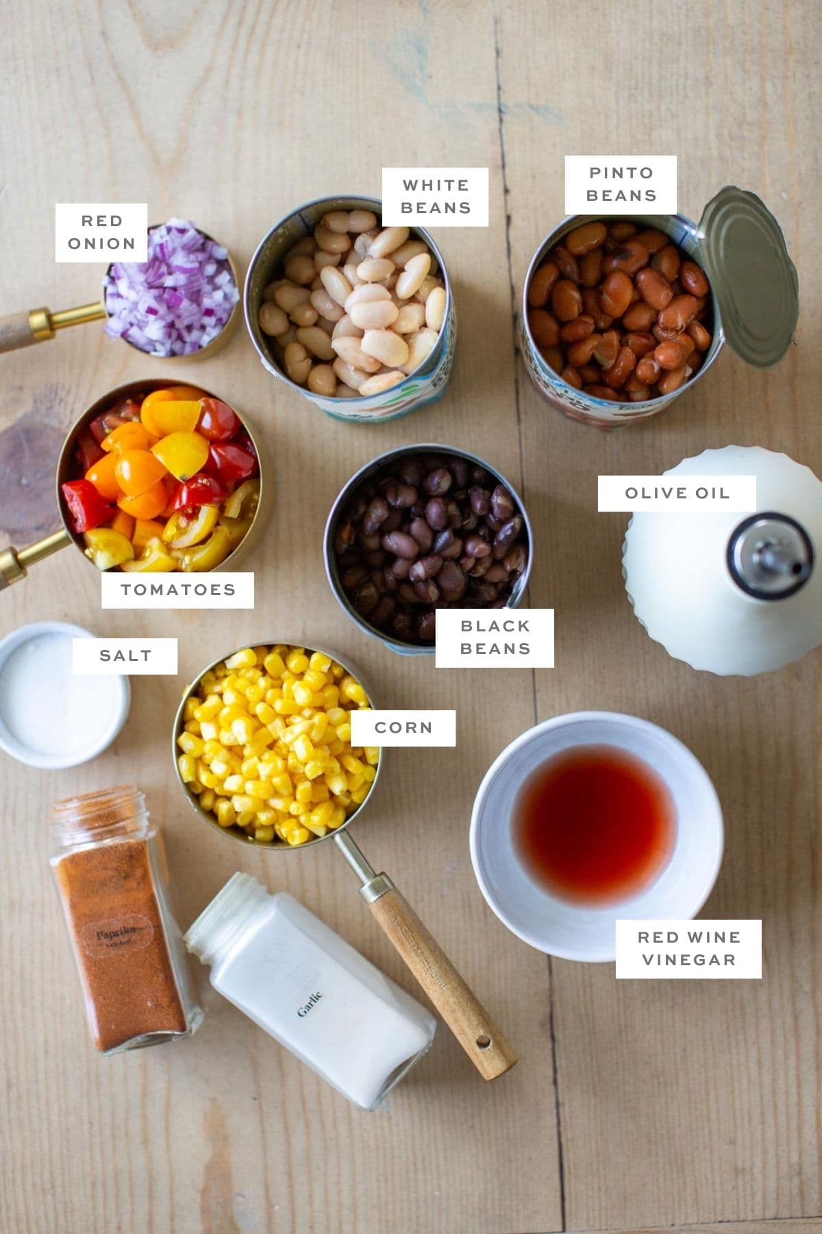 Ingredients for this vegan bean salad gathered in individual cans and bowls with labels.