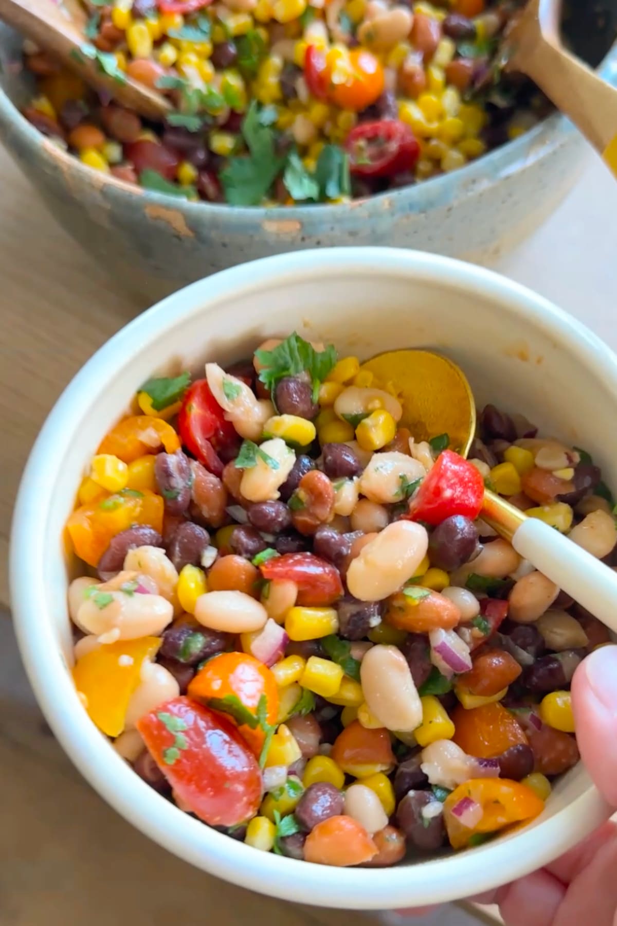 Vegan bean salad with corn, tomatoes, and black beans served in a bowl.