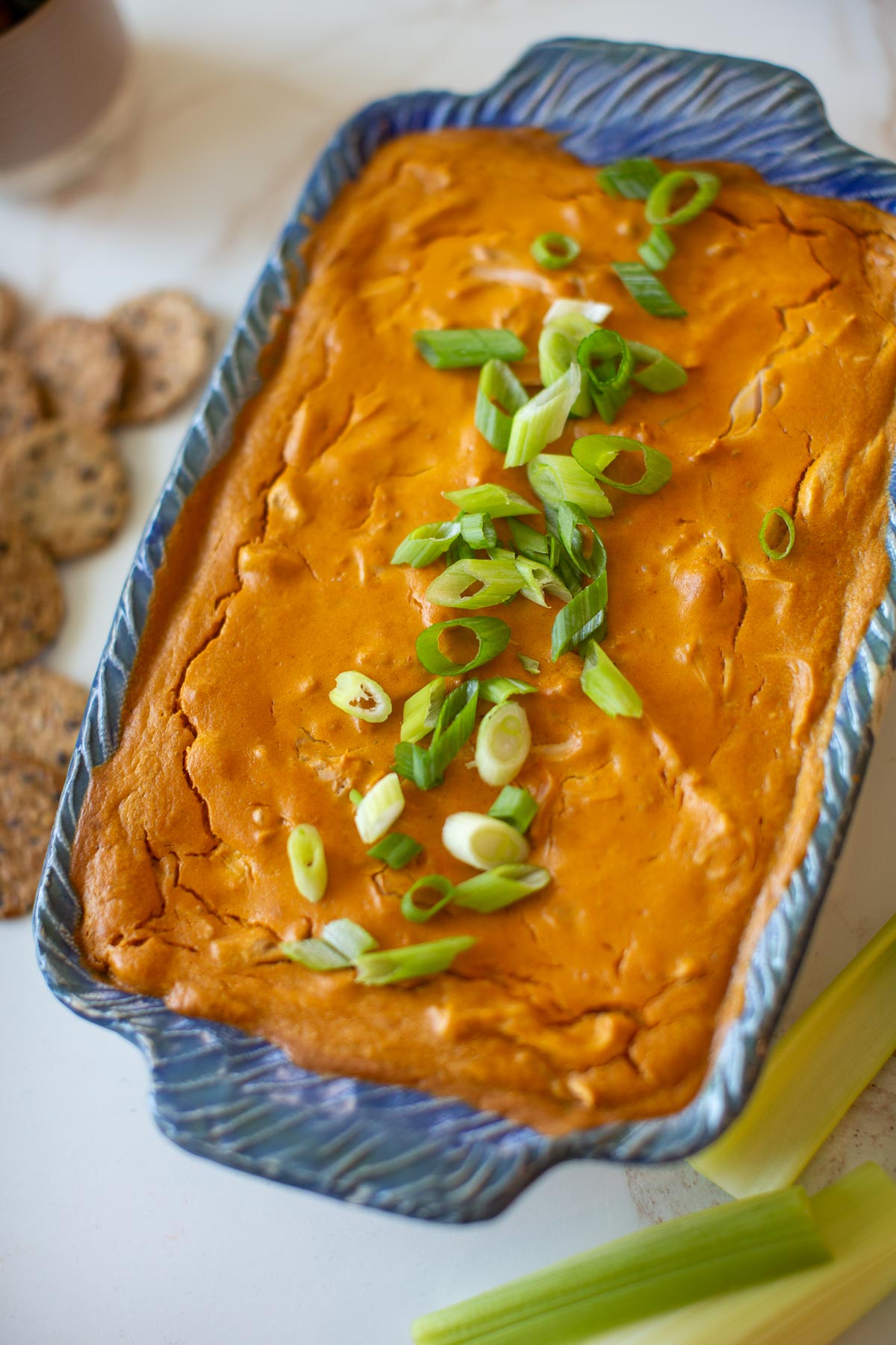 Vegan buffalo chicken dip with celery and green onions.