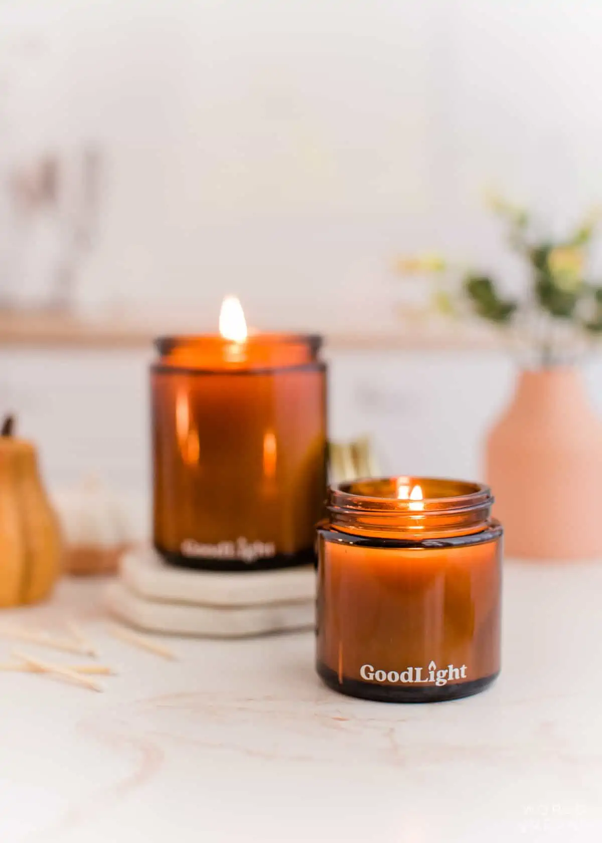 two vegan scented candles burning in glass jars