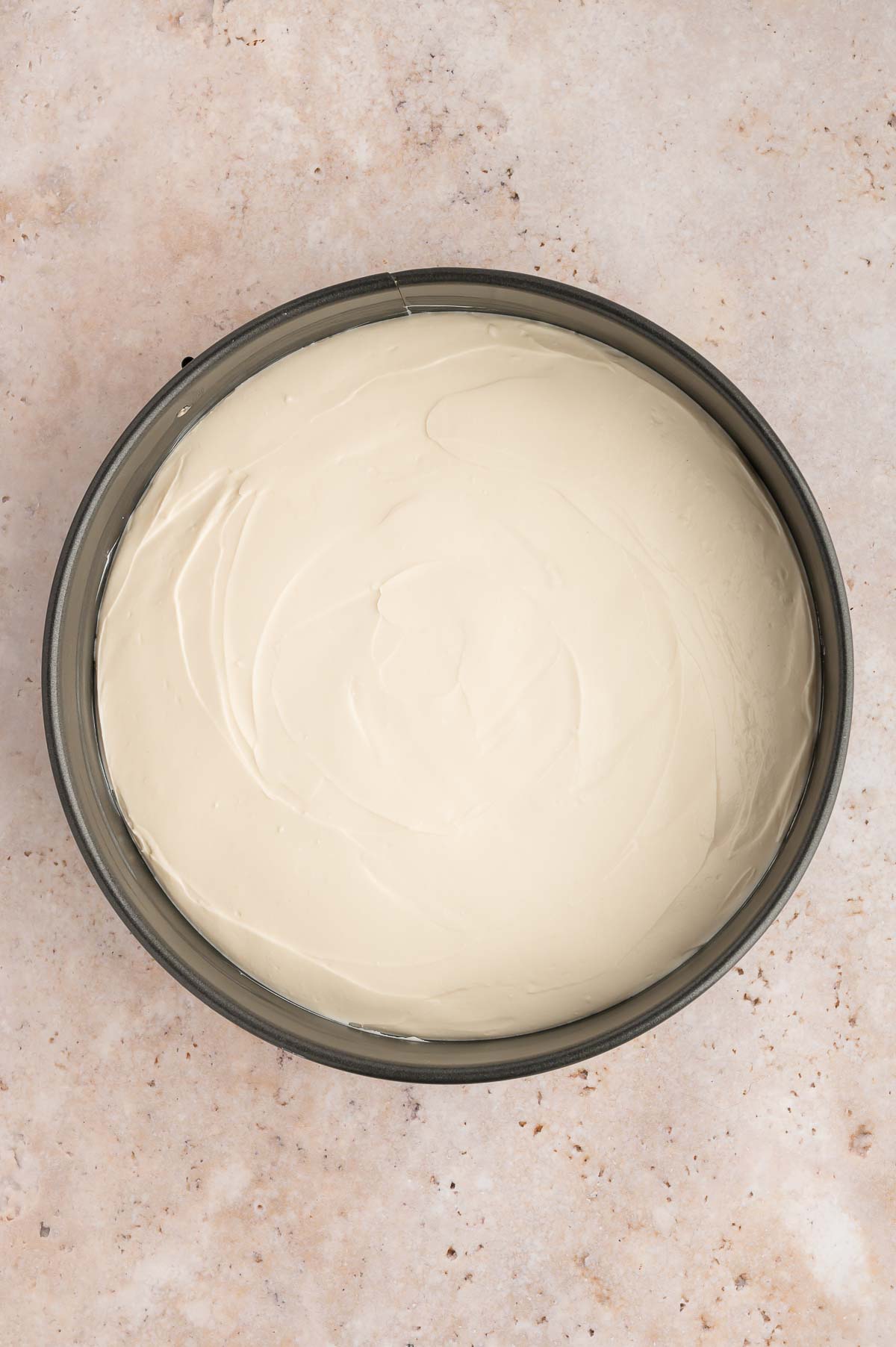 The cheesecake filling added to a springform pan and smoothed out on top.