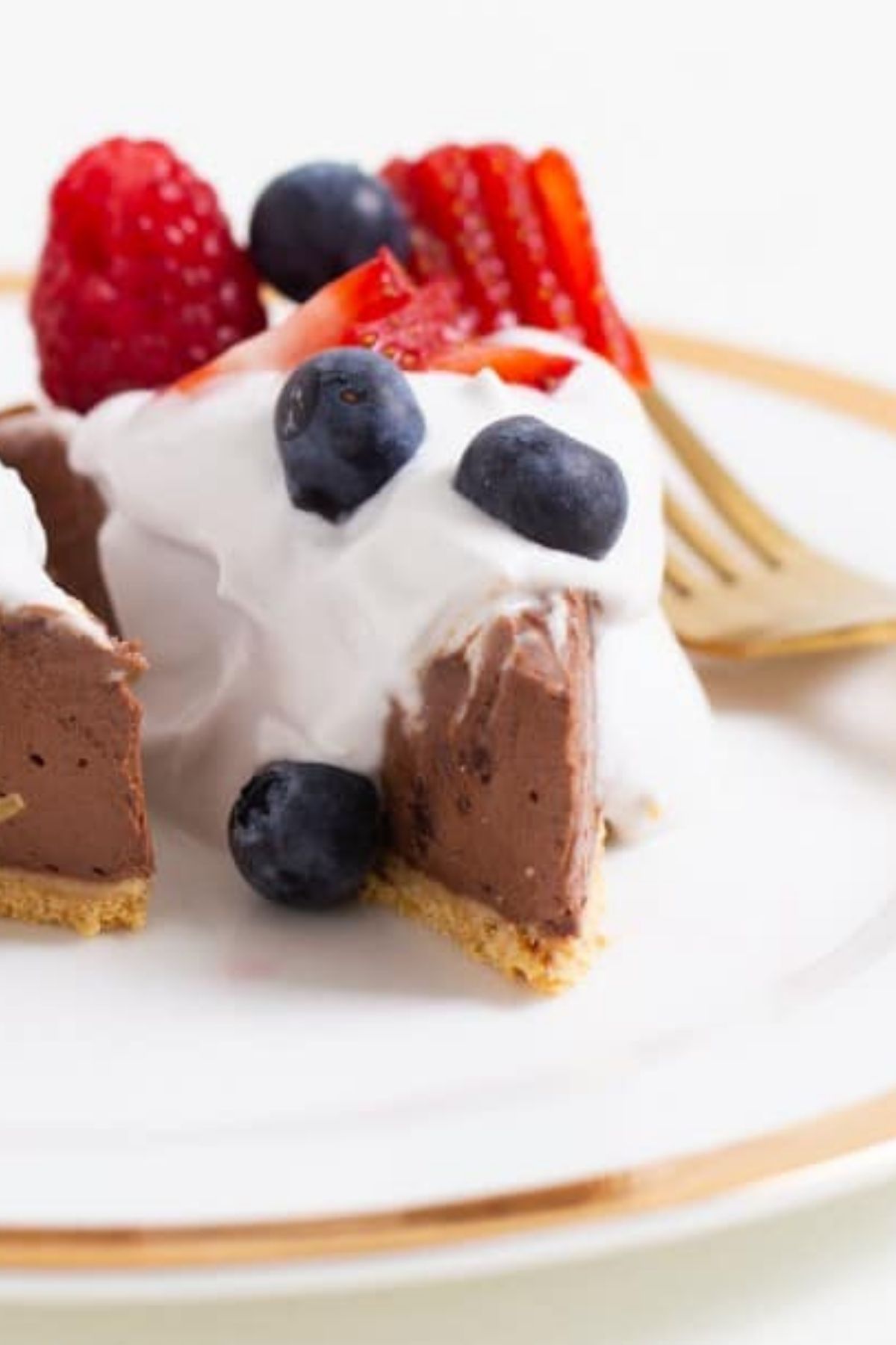 A vegan chocolate pie with berries and dairy-free whipped cream.