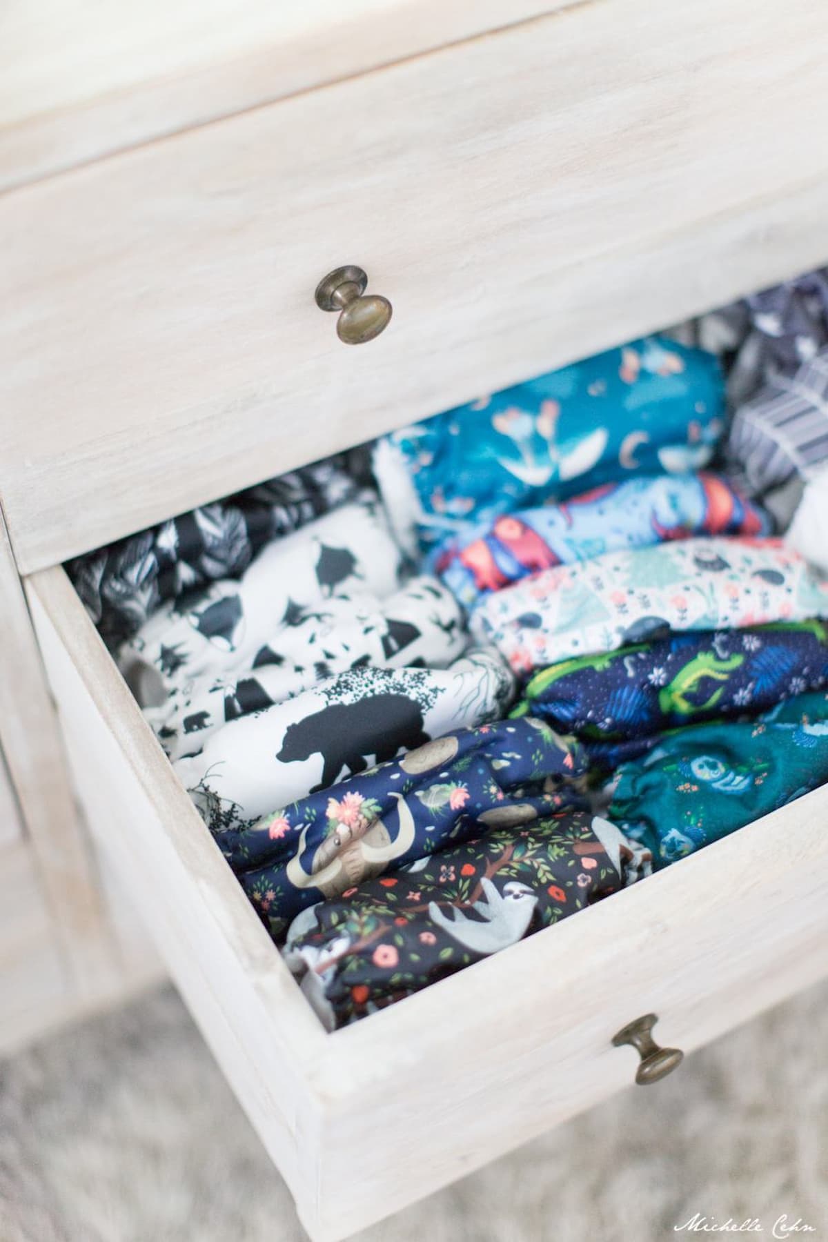 An assortment of vegan cloth diapers in a drawer.