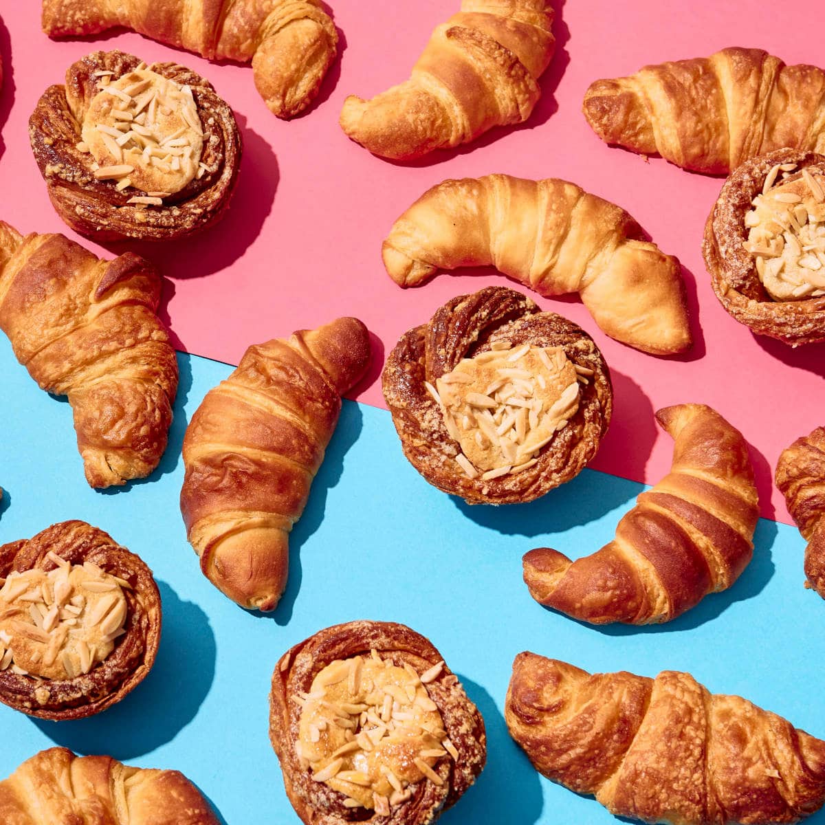 Various vegan croissants on a blue and pink background.