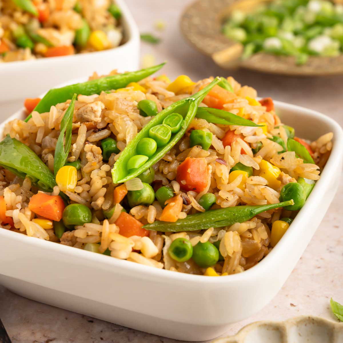 Vegan fried rice served in a bowl and topped with sliced snow peas.
