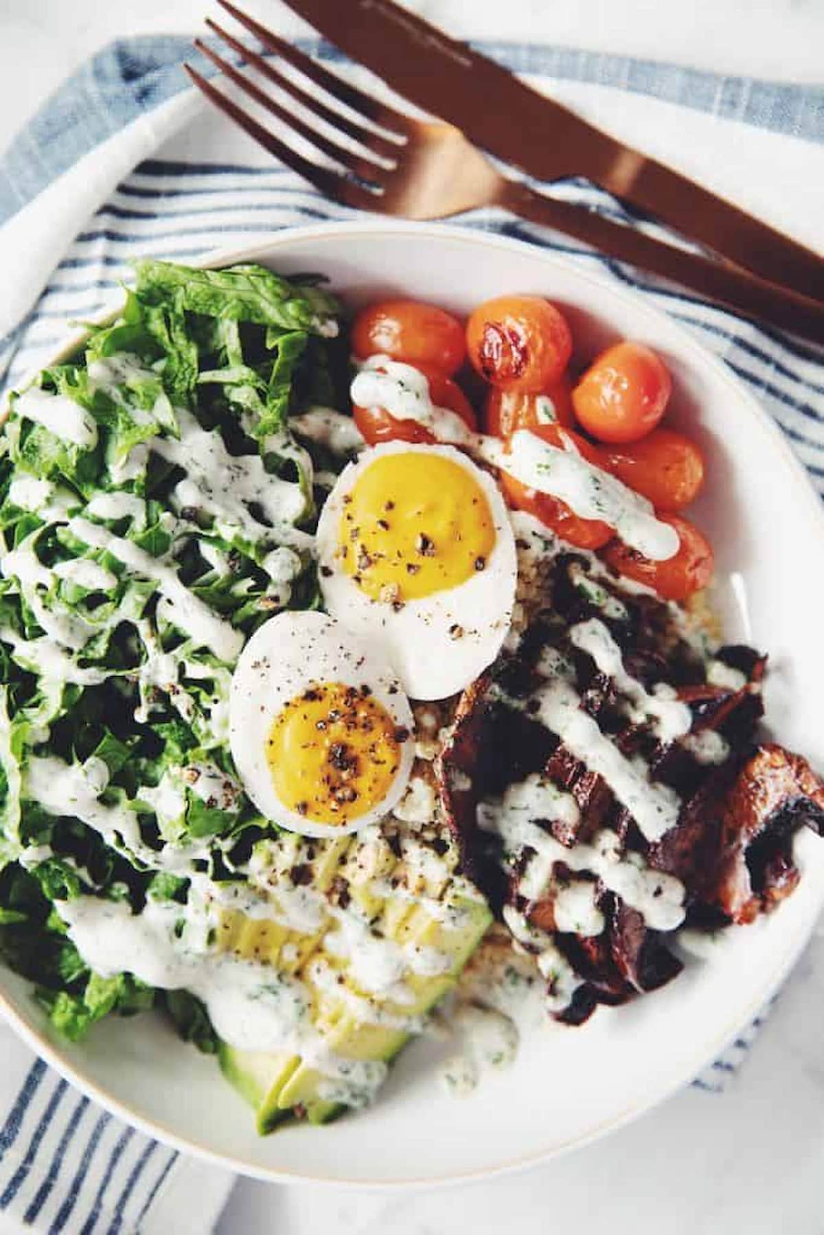 A vegan grain bowl topped with vegan eggs made with silken tofu.