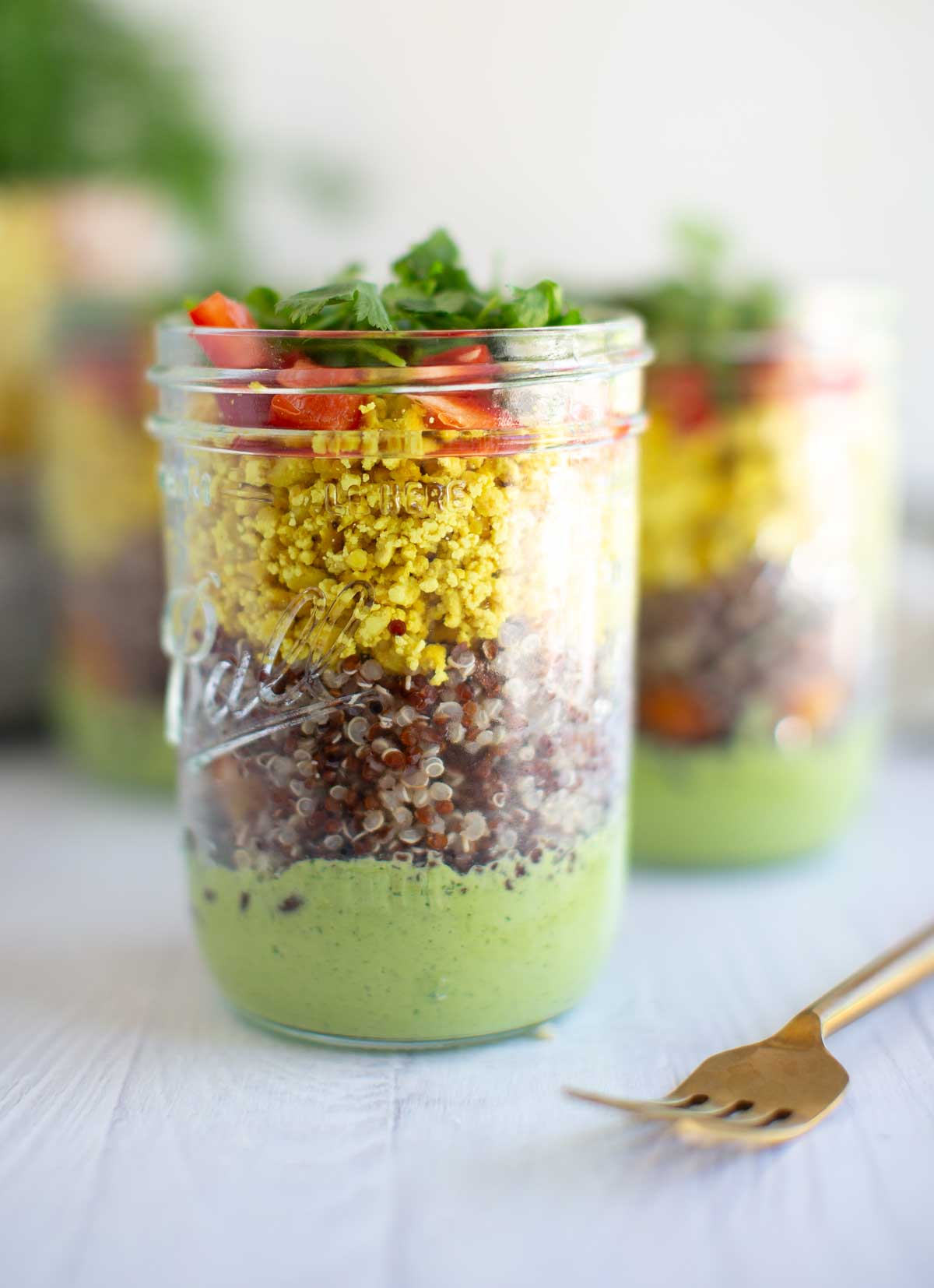 Vegan green goddess dressing layered into a mason jar salad.