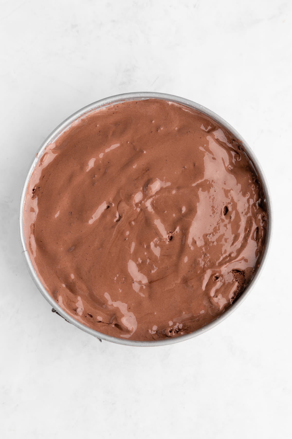 Chocolate vegan ice cream added as the final layer of the vegan ice cream cake in the springform pan.