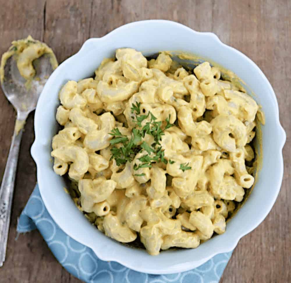 Vegan mac and cheese without cashews, in a serving bowl, topped with chopped parsley.