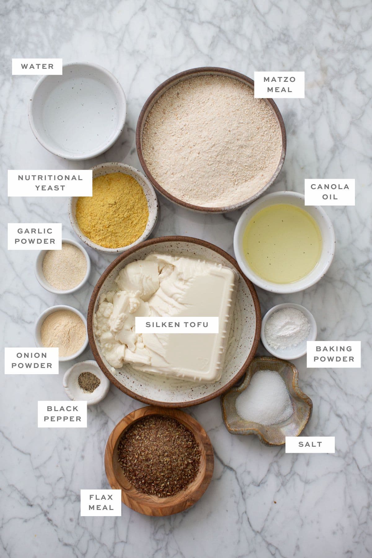 Gathered ingredients for vegan matzo balls, measured into individual bowls with labels.