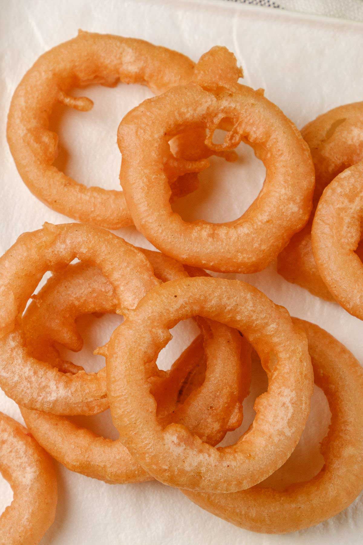 A plate of stacked vegan onion rings—crispy, golden, and perfect for game day.