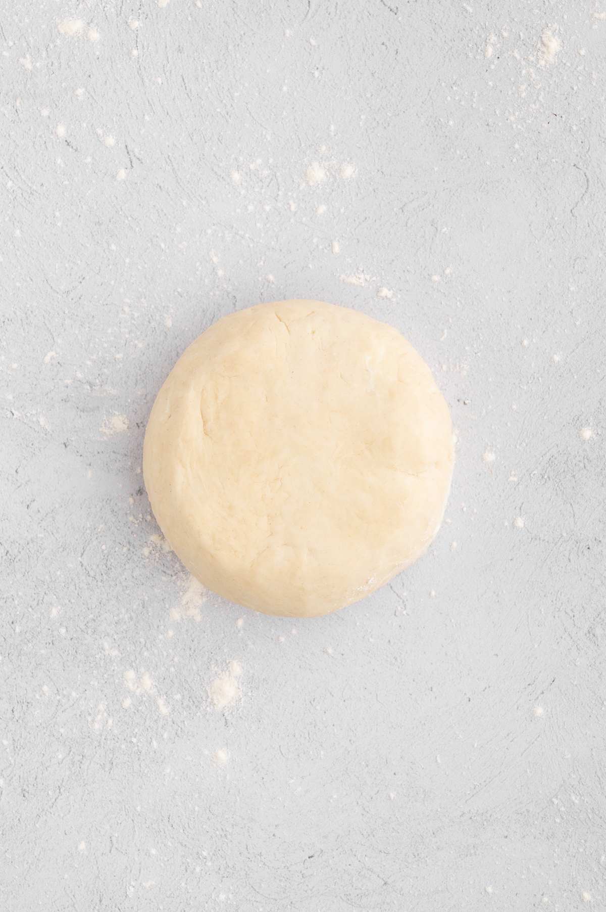 The vegan pie crust dough rolled and flattened into a disc.
