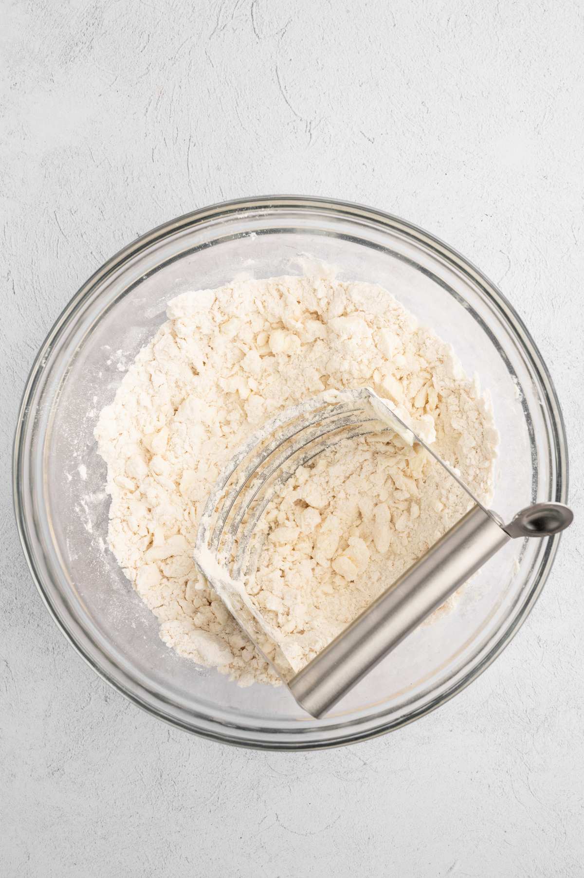 Vegan butter added to the dry ingredients using a pastry cutter.