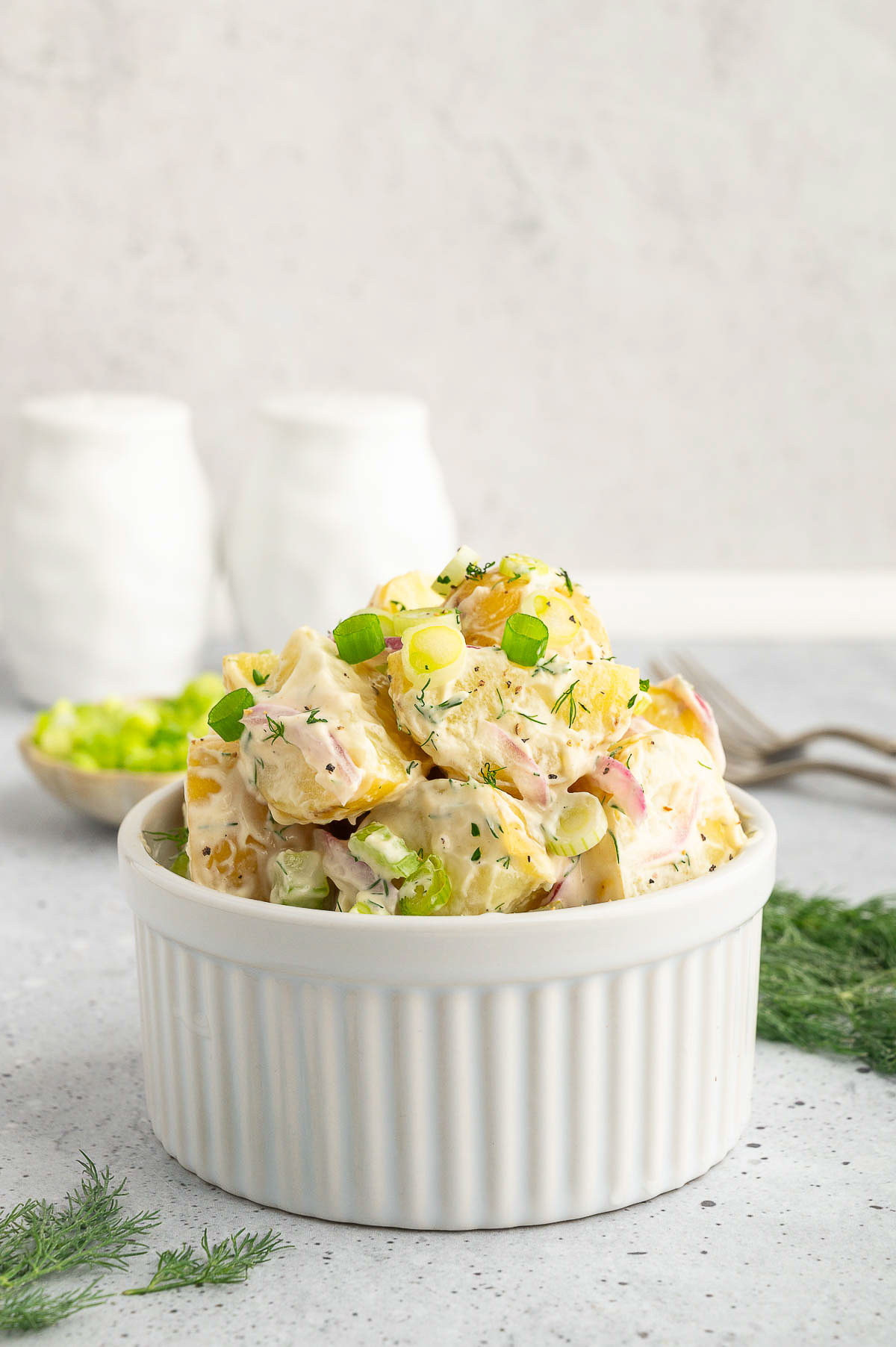 Vegan potato salad in a ramekin on a countertop.