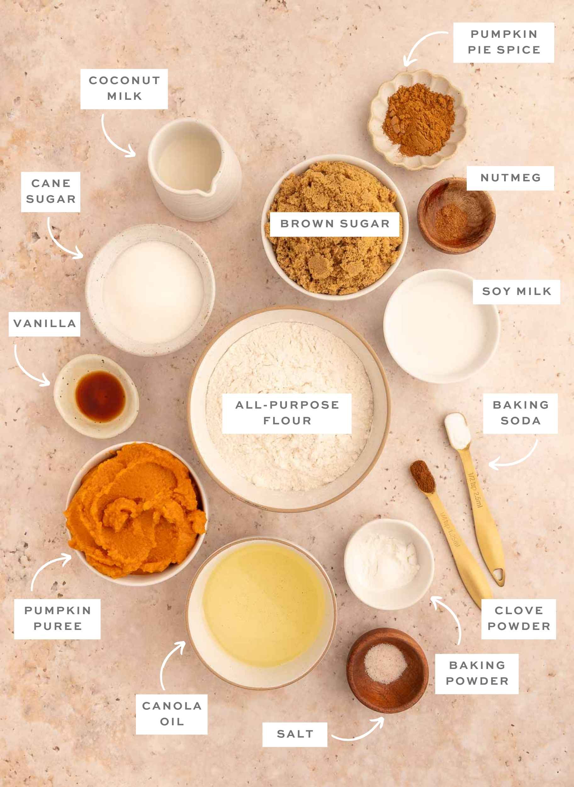 Gathered ingredients for this vegan pumpkin dump cake recipe measured and displayed in individual bowls with labels.