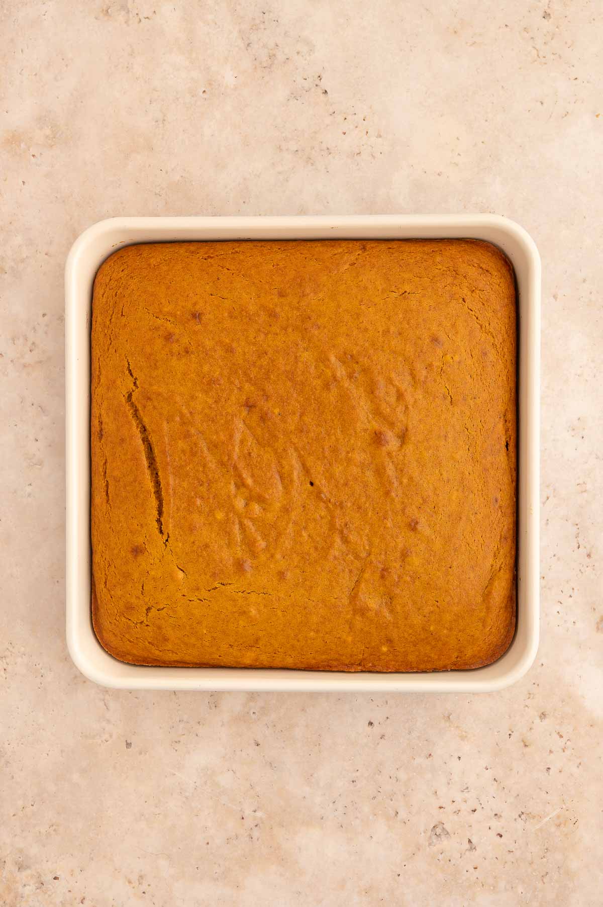 The baked vegan pumpkin dump cake in a white baking dish.