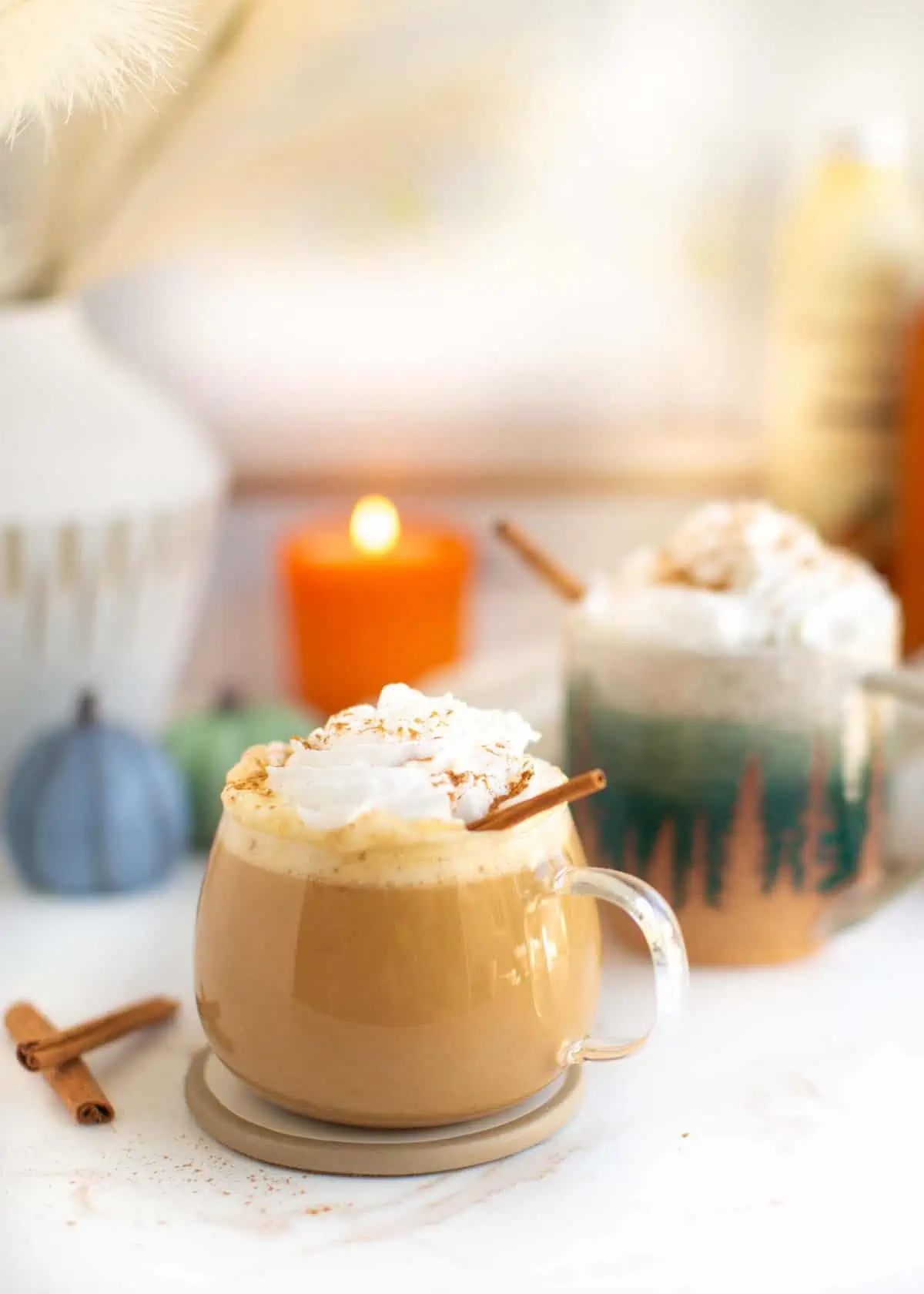 A mug of pumpkin spice latte with vegan whipped cream.