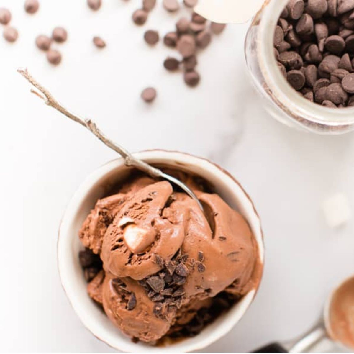 A bowl of vegan rocky road ice cream with chocolate chips.